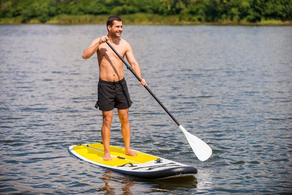 Homem surfando em paddleboard — Fotografia de Stock