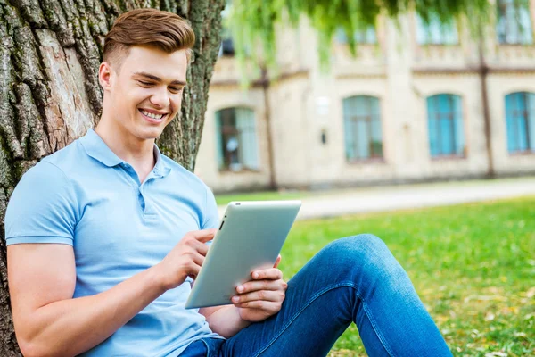 Çimenlerin üzerinde dijital tablet üzerinde çalışan öğrenci — Stok fotoğraf