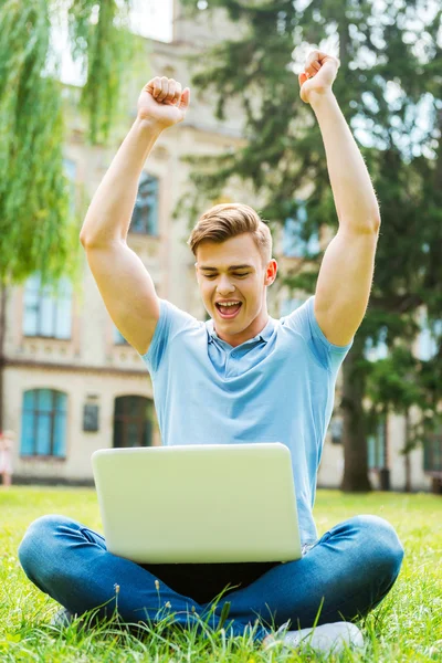 Człowiek patrzy na laptopa i podnoszenie broni — Zdjęcie stockowe