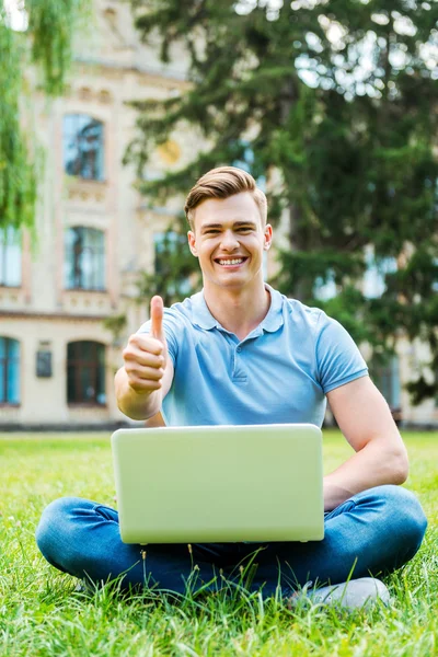 Man visar tummen med laptop — Stockfoto