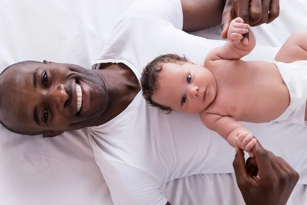 Afrikanischer Mann hält sein kleines Baby — Stockfoto