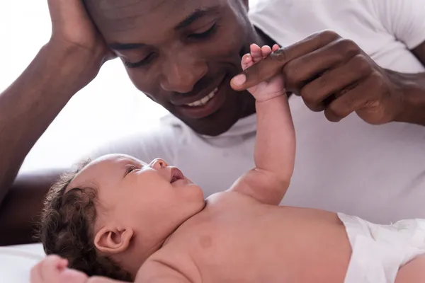 African man playing with his little baby Royalty Free Stock Photos