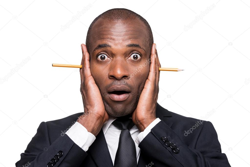 African man holding head in hands with pencil