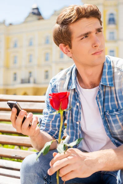 バラを保持している人と携帯電話 — ストック写真