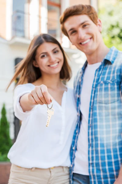 Liebespaar gegen Haus, während Frau Schlüssel hält — Stockfoto