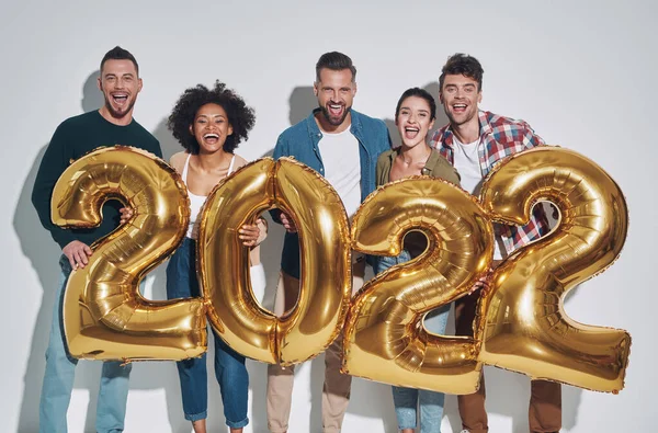 Gruppo di giovani belle persone in abbigliamento casual che trasportano numeri color oro e sorridenti — Foto Stock