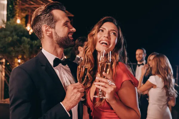这对年轻貌美的情侣穿着正装，一边喝着香槟，一边在豪华派对上消磨时光 — 图库照片