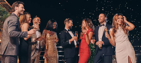 Gruppo di belle persone in abbigliamento formale che comunicano e sorridono mentre trascorrono del tempo alla festa di lusso — Foto Stock