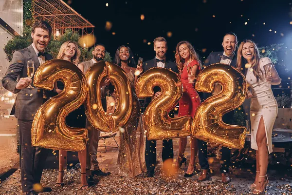 Група красивих людей у формальному одязі з золотими кольоровими номерами та посмішкою — стокове фото