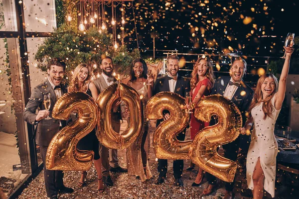Група красивих людей у формальному одязі з золотими кольоровими номерами та посмішкою — стокове фото