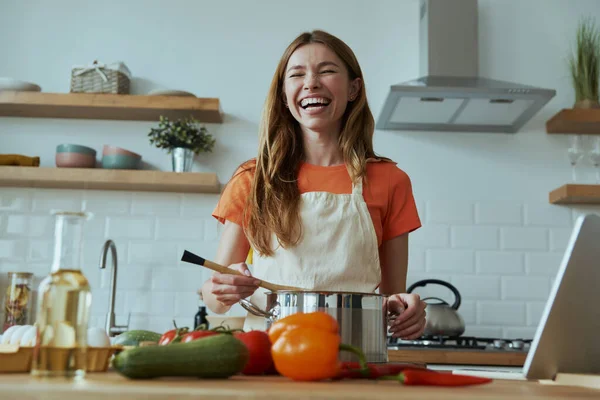 Szczęśliwa Młoda Kobieta Gotuje Zupę Uśmiecha Się Stojąc Kuchni Domowej — Zdjęcie stockowe