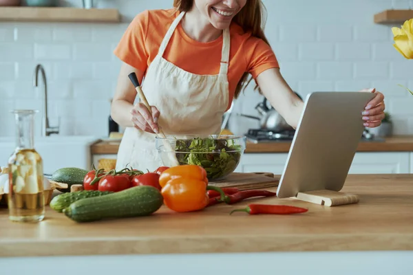 Genç Bir Kadının Yemek Pişirirken Dijital Tablet Kullanırken Mutfağında Durduğu — Stok fotoğraf