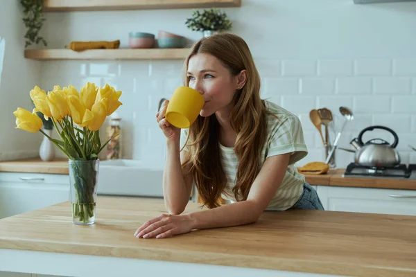 Vacker Ung Kvinna Dricker Kaffe Från Gul Kopp När Står — Stockfoto