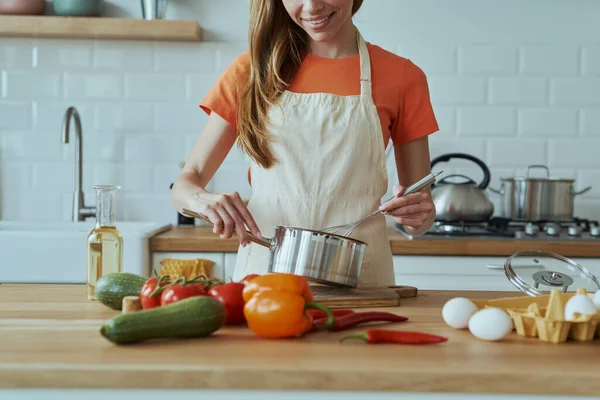 Mutfağında Yemek Pişirirken Tavada Bir Şeyler Karıştıran Genç Bir Kadının — Stok fotoğraf
