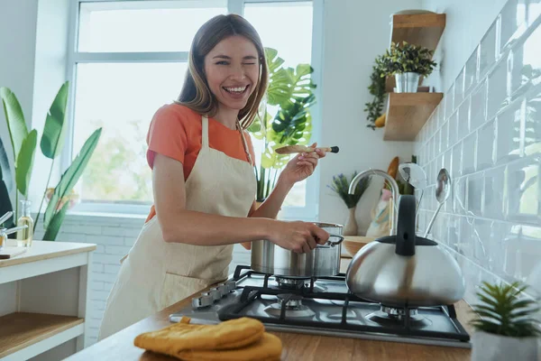 Genç Güzel Bir Kadın Mutfağında Yemek Pişirirken Çorba Tadıyor — Stok fotoğraf