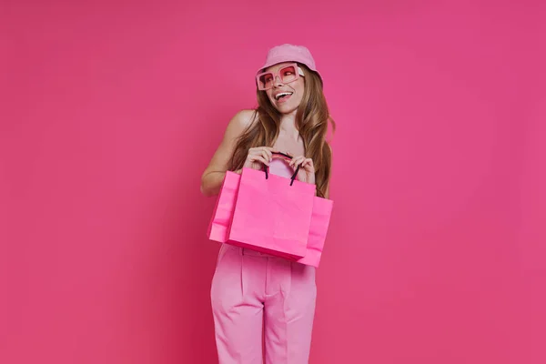 Ενθουσιασμένος Νεαρή Γυναίκα Μεταφέρουν Τσάντες Ψώνια Ενώ Στέκεται Ροζ Φόντο — Φωτογραφία Αρχείου