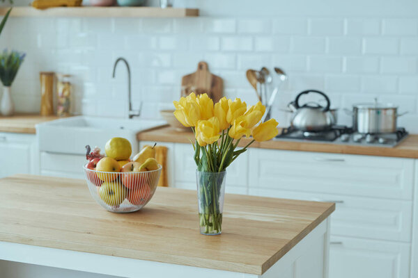 Уютный современный интерьер кухни с белой мебелью и яркими элементами