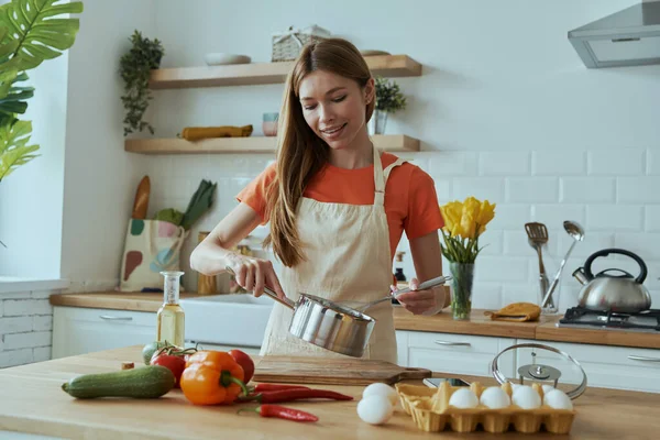 Güzel Genç Bir Kadın Mutfağında Yemek Pişirirken Tavada Bir Şeyler — Stok fotoğraf