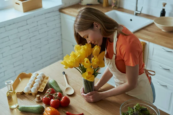 Vista Superior Hermosa Mujer Joven Oliendo Tulipanes Mientras Cocina Cocina —  Fotos de Stock