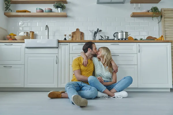 Jovem Casal Amoroso Colagem Enquanto Sentado Chão Inclinado Balcão Cozinha — Fotografia de Stock