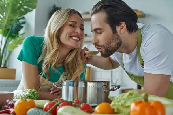 Cheerful Young Couple Tasting Something Pan Domestic Kitchen — Stock Photo, Image