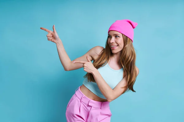 Cheerful Young Woman Pink Hat Smiling Pointing Away While Standing — Stock Photo, Image