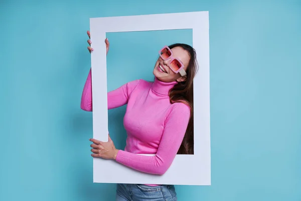 Mooie Jonge Vrouw Zoek Door Een Fotolijstje Terwijl Staan Tegen — Stockfoto