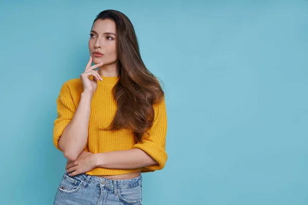 Nachdenkliche Junge Frau Hält Hand Kinn Während Sie Vor Blauem — Stockfoto