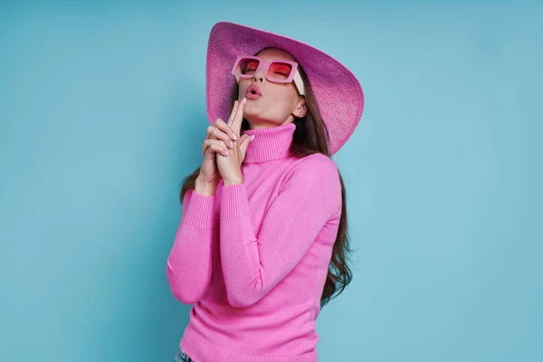 Mulher Atraente Chapéu Rosa Gesticulando Arma Enquanto Contra Fundo Azul — Fotografia de Stock