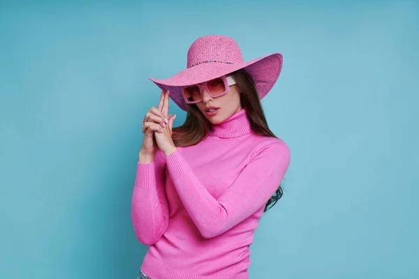 Mulher Atraente Chapéu Rosa Gesticulando Arma Enquanto Contra Fundo Azul — Fotografia de Stock