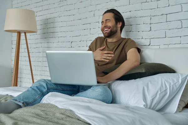 Guapo Joven Riendo Voz Alta Mientras Algo Ordenador Portátil Casa — Foto de Stock