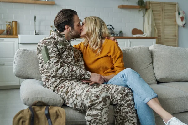 Handsome man in military talking to his wife after coming home from army