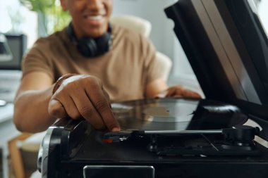 Mutlu çok ırklı adamın yakın plan çekimleri turntable 'a plak koyuyor.