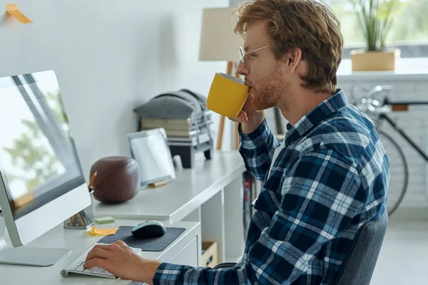 Uomo Sicuro Che Beve Caffè Usa Computer Mentre Seduto Nel — Foto Stock