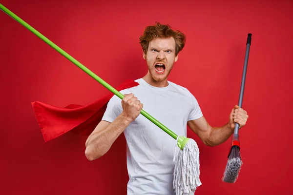 Furious Man Superhero Cape Carrying Cleaning Equipment While Red Background — Stock Photo, Image