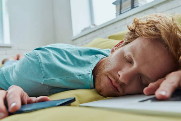 Tired Redhead Man Napping Couch Laptop Smart Phone Laying Him — Stock Photo, Image