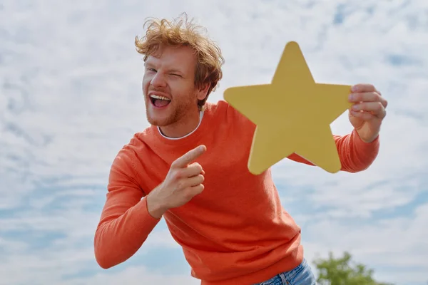 Jovem Ruiva Alegre Homem Mostrando Estrela Amarela Sorrindo Com Céu — Fotografia de Stock
