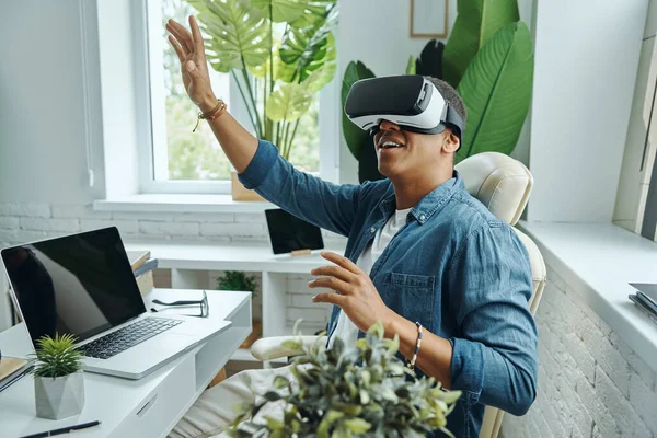 Радостный Человек Смешанной Расы Очках Виртуальной Реальности Жесте Сидя Столом — стоковое фото