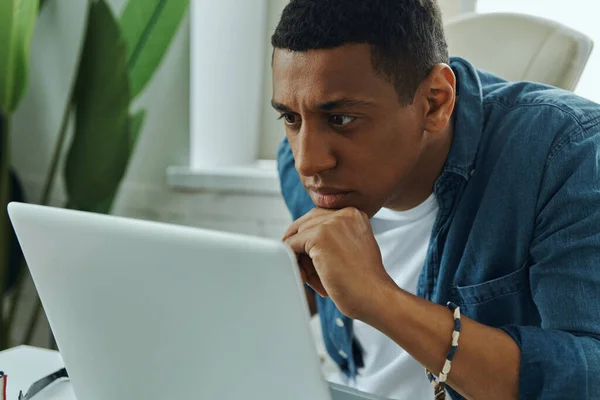 Joven Hombre Raza Mixta Confiado Mirando Computadora Portátil Mientras Está — Foto de Stock