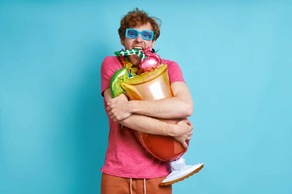 Happy Man Hawaiian Necklace Carrying Cocktail Shaped Balloon Blue Background — Stock Photo, Image