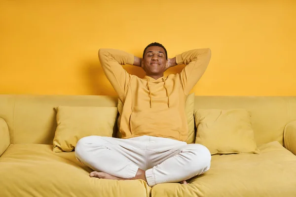 Despreocupado Misto Homem Raça Relaxante Sofá Com Fundo Amarelo — Fotografia de Stock