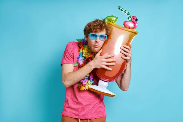 Playful Man Hawaiian Necklace Carrying Cocktail Shaped Balloon Blue Background — Stock Photo, Image