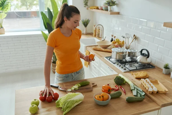 Genç ve güzel bir kadının ev mutfağında yemek pişirmesi.