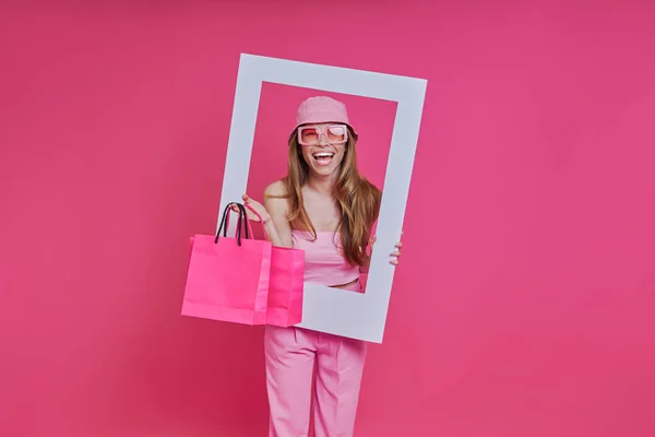 Mujer Alegre Mirando Través Marco Imagen Llevando Bolsas Compras — Foto de Stock