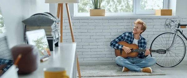 Glad Ung Man Som Spelar Akustisk Gitarr När Han Sitter — Stockfoto