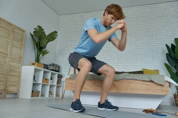 Joven Concentrado Ropa Deportiva Haciendo Ejercicio Casa —  Fotos de Stock