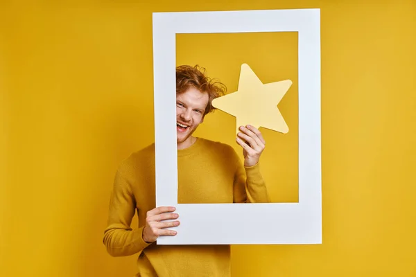 Knappe Man Met Ster Terwijl Hij Door Een Fotolijstje Kijkt — Stockfoto