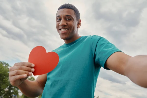 Feliz Homem Raça Mista Fazendo Selfie Segurando Forma Coração Papel — Fotografia de Stock