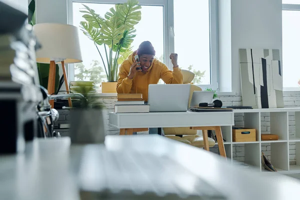 Alegre Hombre Multirracial Hablando Por Teléfono Utilizando Ordenador Portátil Mientras — Foto de Stock