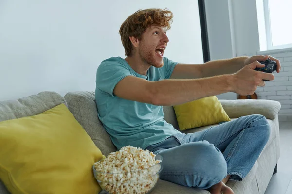 Joven Emocionado Jugando Videojuegos Mientras Está Sentado Sofá Casa —  Fotos de Stock